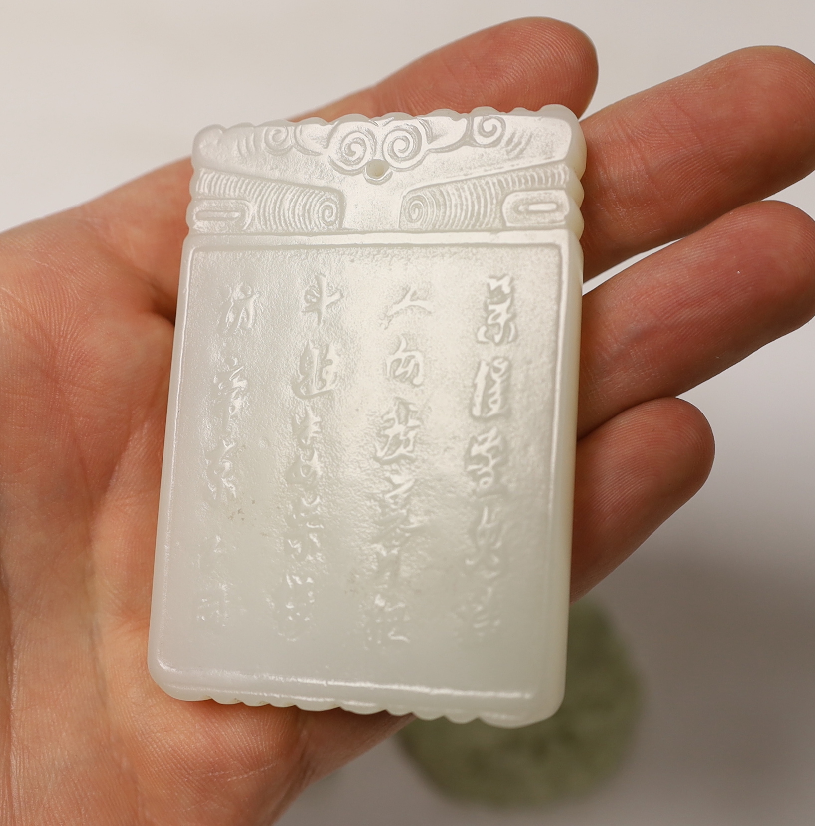 A Chinese white jade pendant plaque and three jadeite pendants, largest 7cm